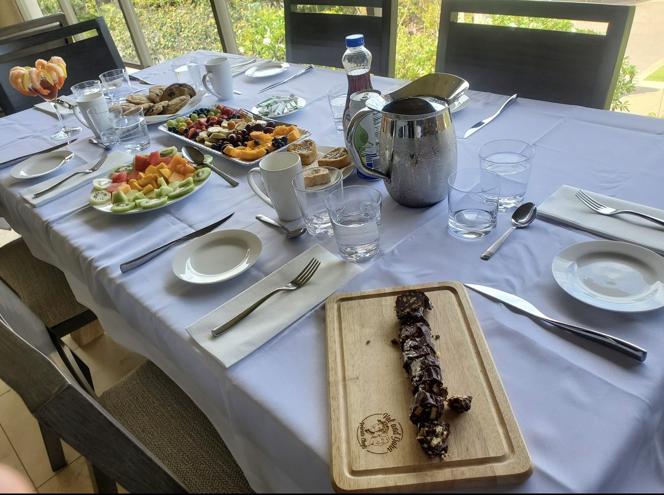 A breakfast table with pastries, fruit and coffee