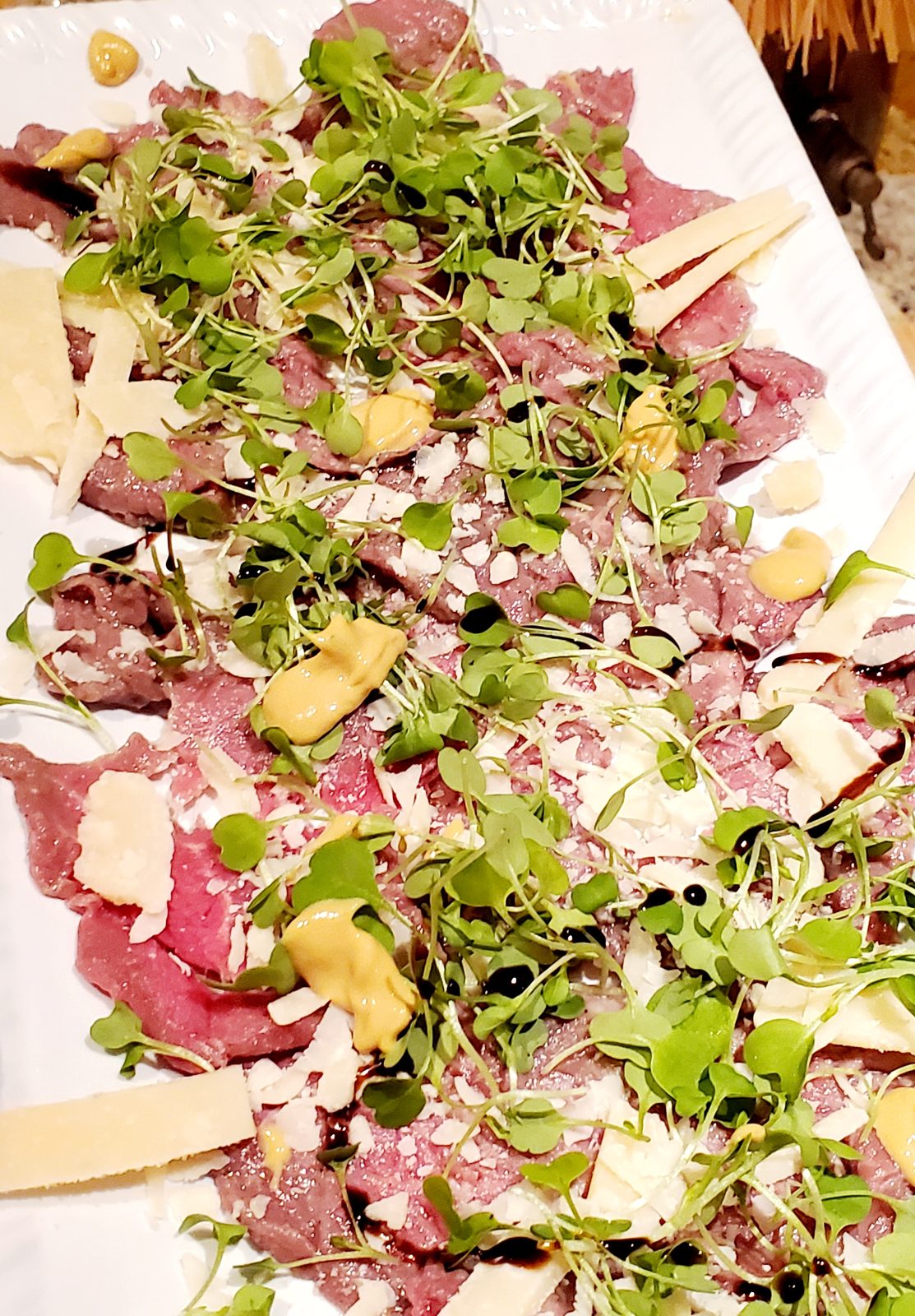 Carpaccio with microgreens and shaved parmesan