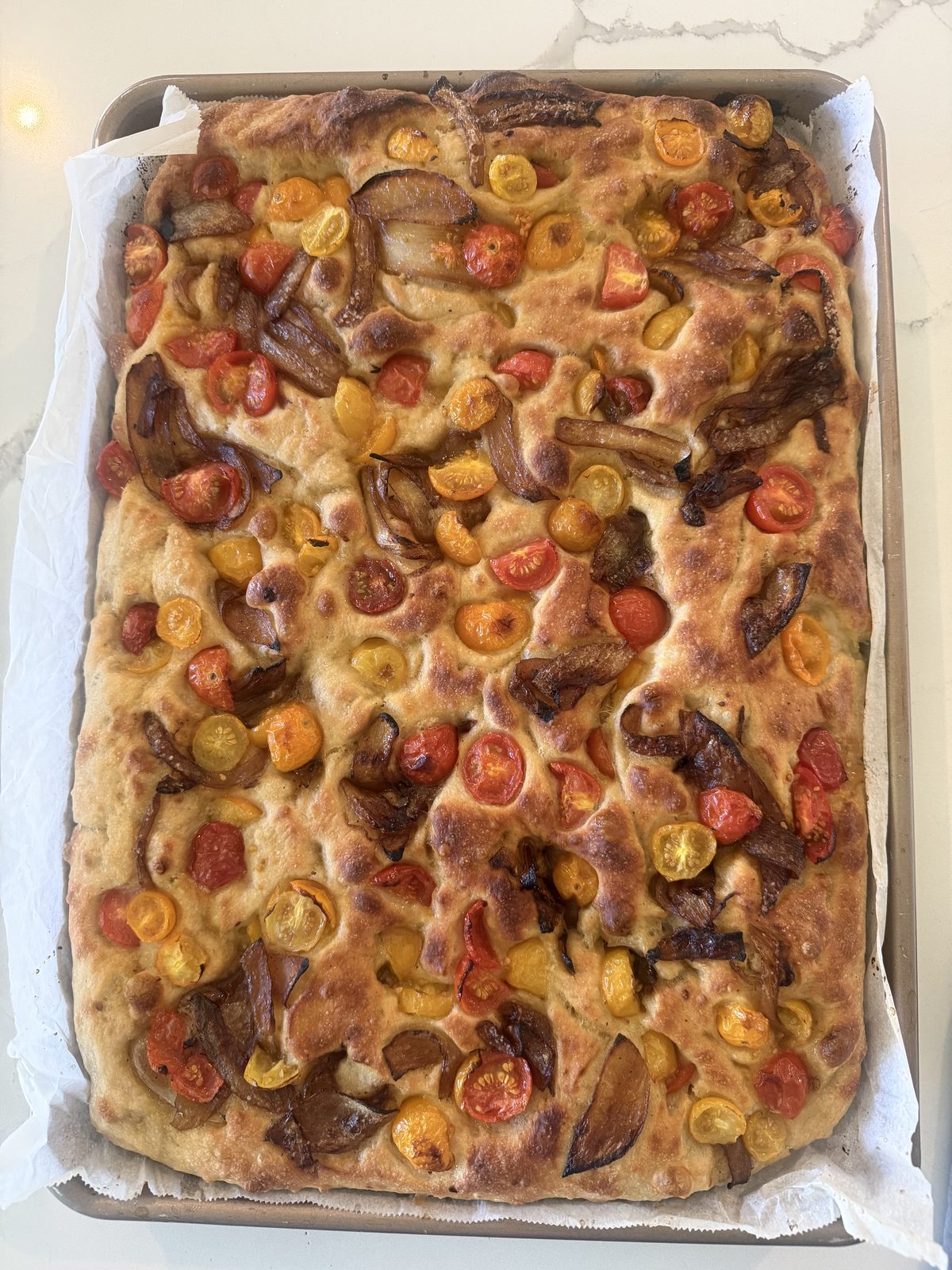 Home-made focaccia with cherry tomatoes and caramelized onion