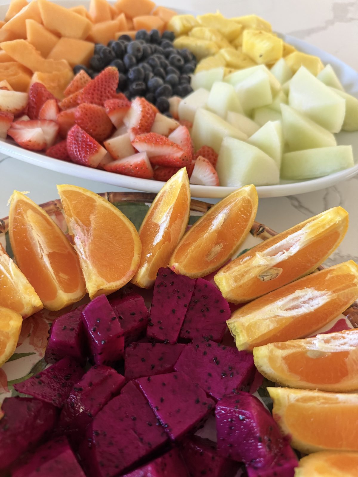 Fresh fruit platter with dragon fruit, orange, strawberries and melon