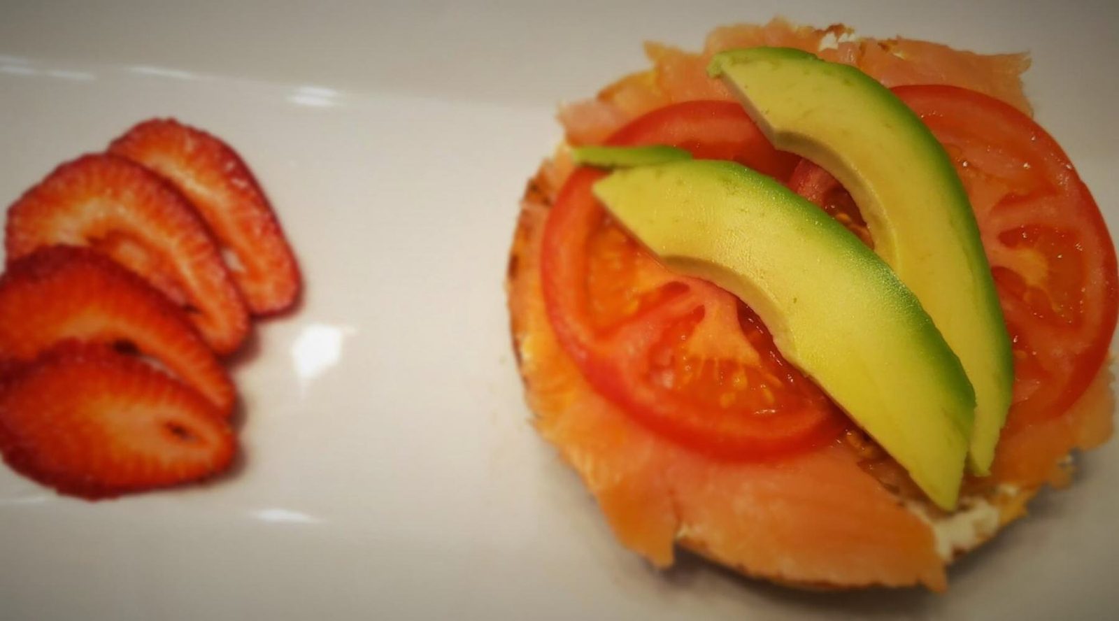 Bagel with cream cheese smoked salmon tomato avocado